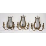 Set of three Regency style brass twin branch wall lights, of U shaped form and beast light branches,