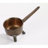 A small bell metal 17th Century skillet, on three legs, the rear leg having a hoofed foot, the