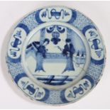 18th Century Delft plate, in blue with two Oriental figures in a room and a geometric edge, 23cm