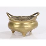 Chinese brass censer, with arched handles above the squat body and tripod supports, six character