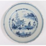 18th Century Delft charger, decorated with an Oriental scene of pagodas, mountains and lakes, 30cm