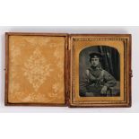 19th Century sixth plate ambrotype of a sailor, seated position with an arm resting on a table,