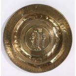 17th century German brass alms dish, with Adam and Eve embossed convex roundel surrounded with