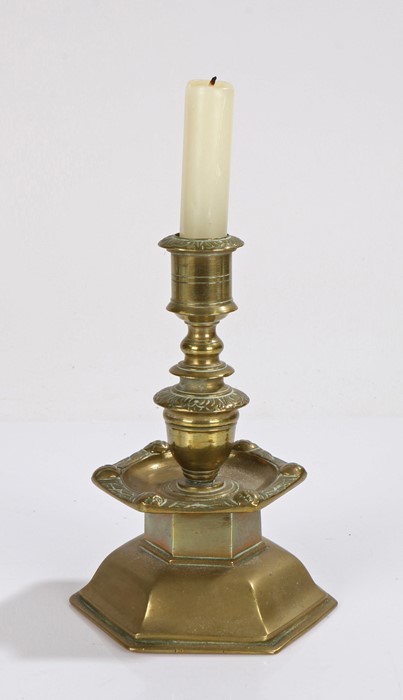 Brass candlestick, with a stepped stem and faces to the sconce edge above the arched base, 18cm