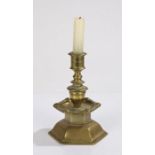 Brass candlestick, with a stepped stem and faces to the sconce edge above the arched base, 18cm