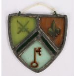 Stained glass panel, in the form of a shield with a key, fleur de lis and crossed swords, 15cm