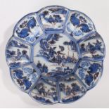 18th Century Dutch Delft plate, the centre decorated with figures holding a flag with a conforming