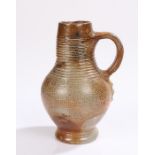 17th Century German salt glaze jug, with ring turned decoration and bulbous body and loop handle,