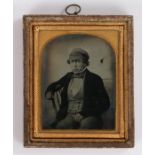 19th Century ninth plate ambrotype, of a seated man in a cap, the rear of the case with the label