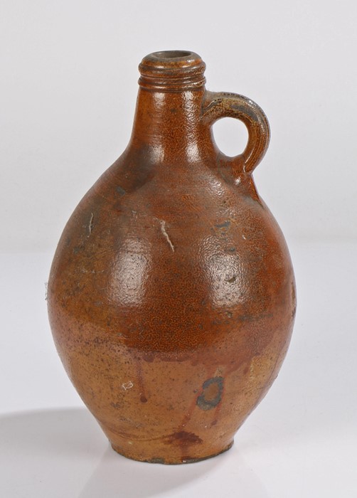 Early 18th Century salt glaze pottery jug, in brown with a short neck and handle above the bulbous