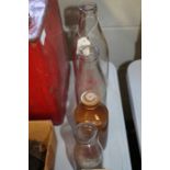 Graduated set of three glass milk bottles, with red lettering "G.W. Lord, Glebe Farm Dairy,