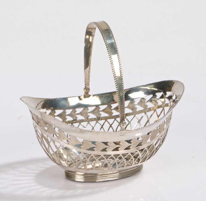 Dutch white metal basket, of pierced oval form with beaded swing handle and loaded foot, 9.5cm wide,