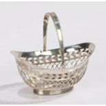 Dutch white metal basket, of pierced oval form with beaded swing handle and loaded foot, 9.5cm wide,