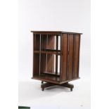 20th Century oak revolving bookcase, of square form, having oak slatted sides and raised on tri-foil