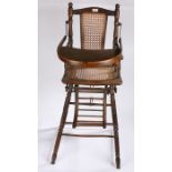 Child beechwood high chair, with an arched back above a caned seat and drop down tray on turned