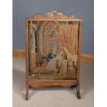 Victorian style fire screen, with fret carved carrying handle, the frame inset with an embroidery