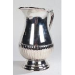 Good quality silver plated jug, in the George III taste, with scroll handle and half fluted body,