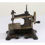 Victorian child's toy sewing machine, with black lacquer and gilt overlay, 18cm wide