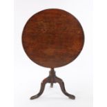 George III oak occasional table, having circular tilt top above a turned column and tripod legs,