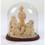 Victorian wax work carving, in the form of three figures and a seated dog within a garden setting,