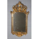 George III style gilded wall mirror, having pierced scrolling pediment above a shaped mirror with
