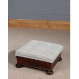 Victorian mahogany footstool, with striped button down upholstery and raised on four bun feet,