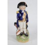 Early 20th Century Staffordshire toby jug modelled as Lord Nelson stood by a canon on naturalistic