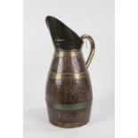 Oak and brass jug, of large proportions, the brass spout with curved handle and brass bound barrel