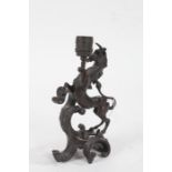 20th Century bronze candlestick, in the form of a unicorn raised on scroll base, 22cm high