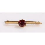 9 carat gold garnet set brooch, with a central garnet set to the bar, gross weight 1.8 grams