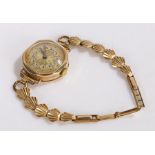 9 Carat gold wristwatch,with gold dial and Arabic numerals and a rolled gold shell strap, gross