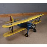 Petrol powered model plane, with blue fuselage, yellow wings and tail with stars and stripes
