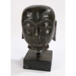 Indian bust in the form of a buddha's head, raised on a black square plinth, 21cm high