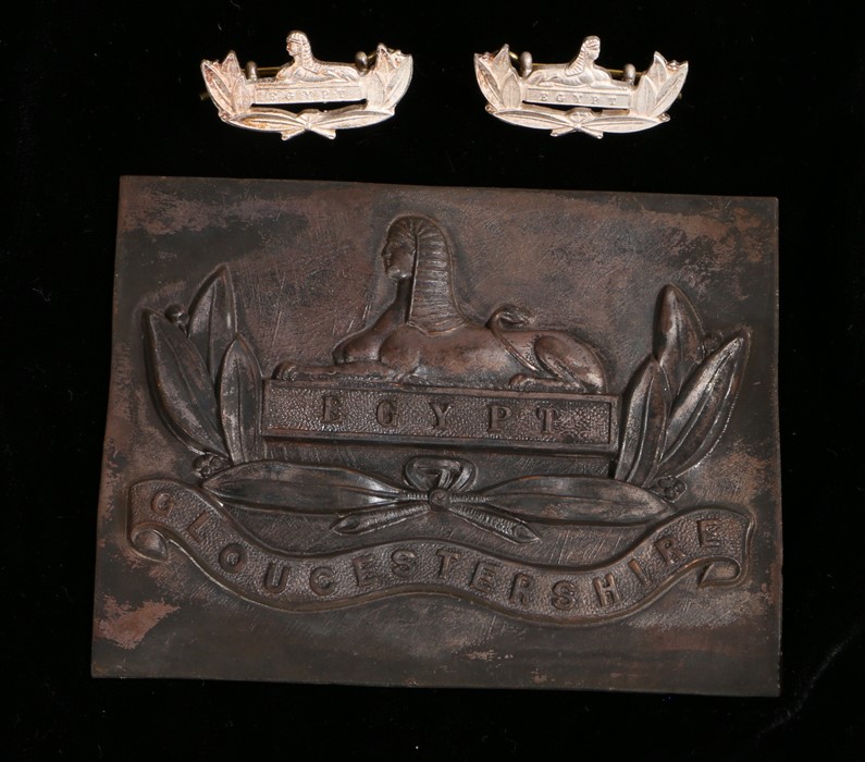 Metal plaque and collar badges to the Gloucestershire Regiment,