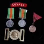 Two Second World War Defence Medals together with an embroidered shoulder title to the Loyals (The