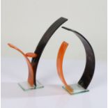 Pair of modernist glass sculptures, in black and orange arches, 26cm high and 25cm high, (2)