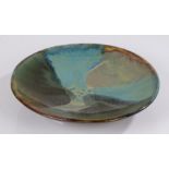 Studio pottery dish, of circular shallow form, glazed in turquoise, greens and browns, marked to