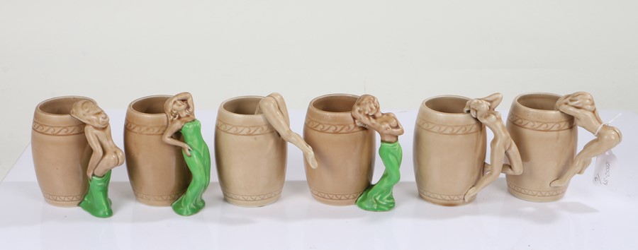 Six Art Deco ceramic mugs, each with stylised handles in the form of nude ladies, each glazed in