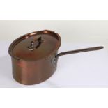 Large copper saucepan, of oval shape and with iron carrying handle, 33cm wide