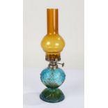 Small coloured glass oil lamp, with amber glass chimney above a blue and green glass reservoir, 33.