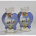 Pair of pottery vases, decorate with grapes above blue hatched panels and a Dutch canal scene,