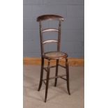 Victorian child's correctional chair, the high back with an arched top rail above a cane seat and