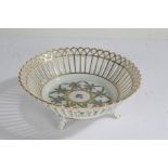 Dresden porcelain basket, having gilded pierced rim, centred with flowers, raised on four feet, 16cm