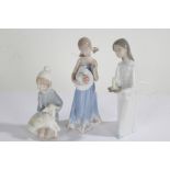 Three various Lladro figurines, the first of a young girl holding a chamberstick, 20cm high, the