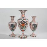 Garniture of three porcelain vases, each with flared necks and of baluster form, decorated with