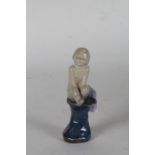 Royal Doulton stoneware figure, by Leslie Harradine, modelled as a seated boy on a blue glazed