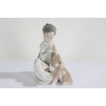 Lladro figure, in the form of a seated child with a dog, 19cm high