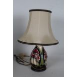 Moorcroft pottery table lamp, with stylised poppy design, raised on circular base, 22cm high