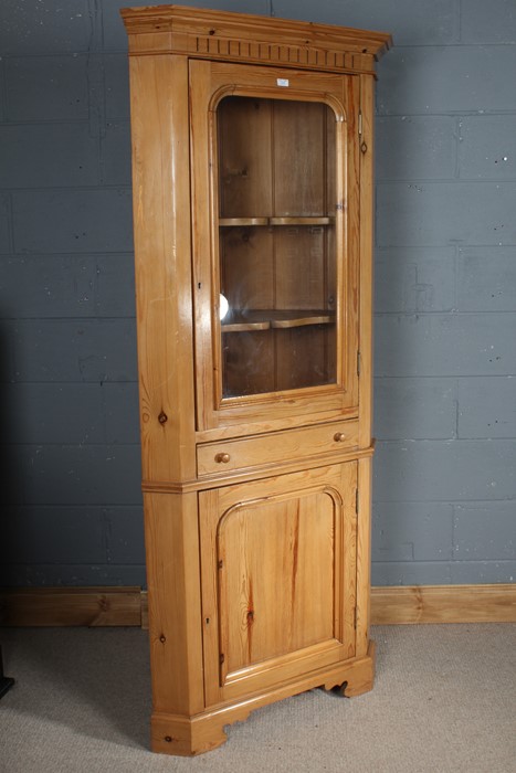 Pine corner cupboard, the glazed door opening to reveal two shelves, above a single drawer and a