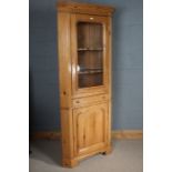 Pine corner cupboard, the glazed door opening to reveal two shelves, above a single drawer and a